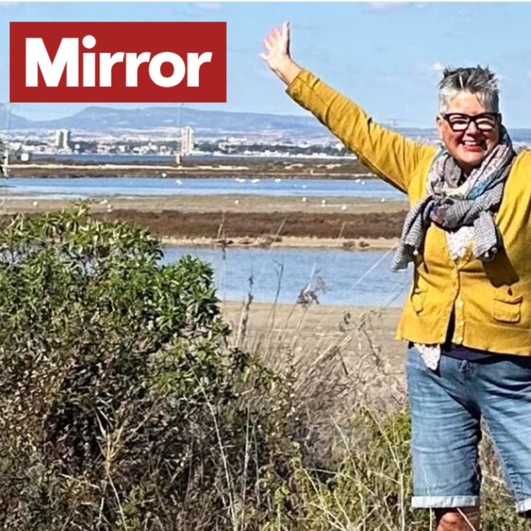 Lozzie George in front of sea in Spain with "Mirror" in top corner 